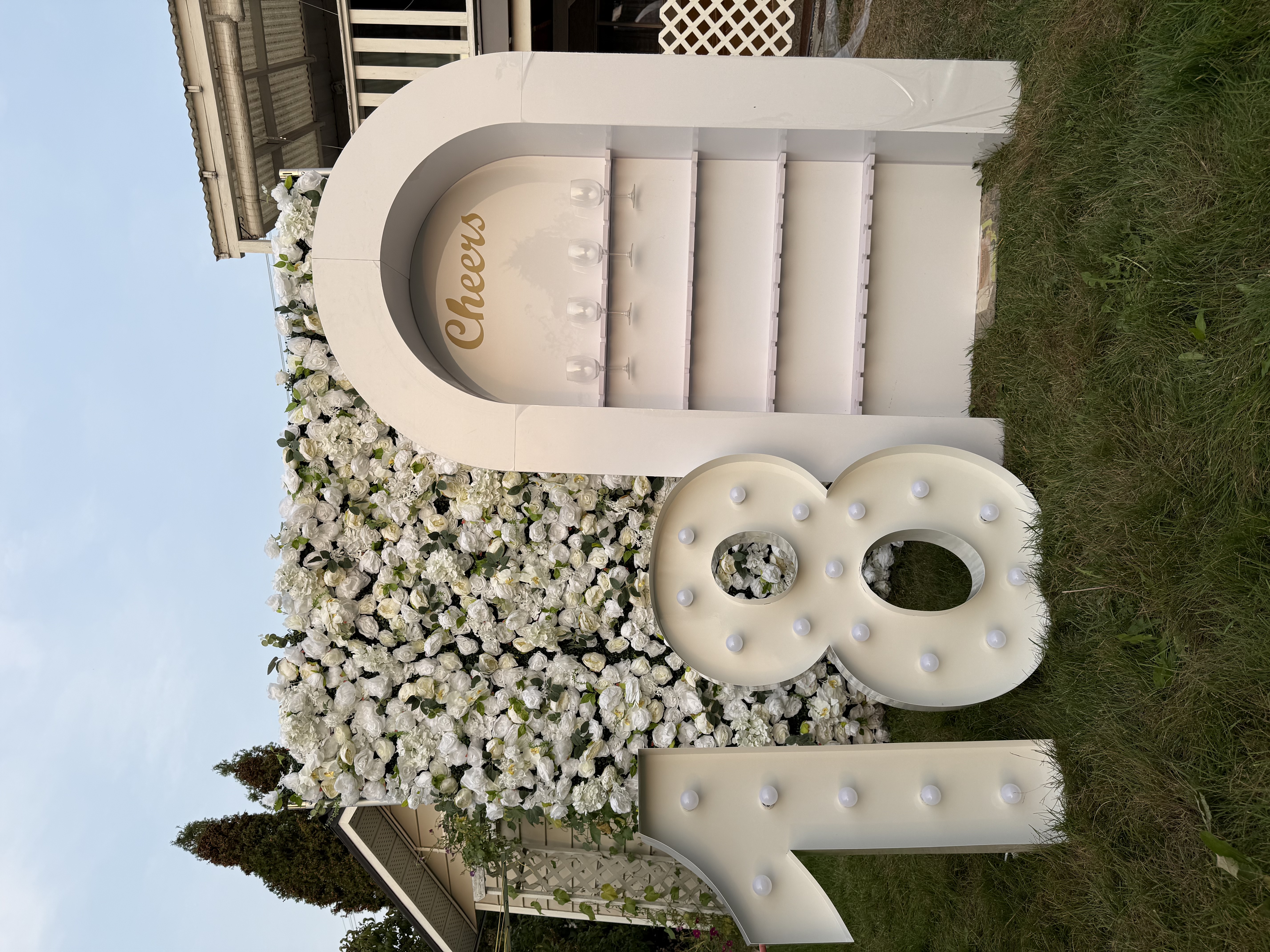 18 marquee numbers with flower wall and arch